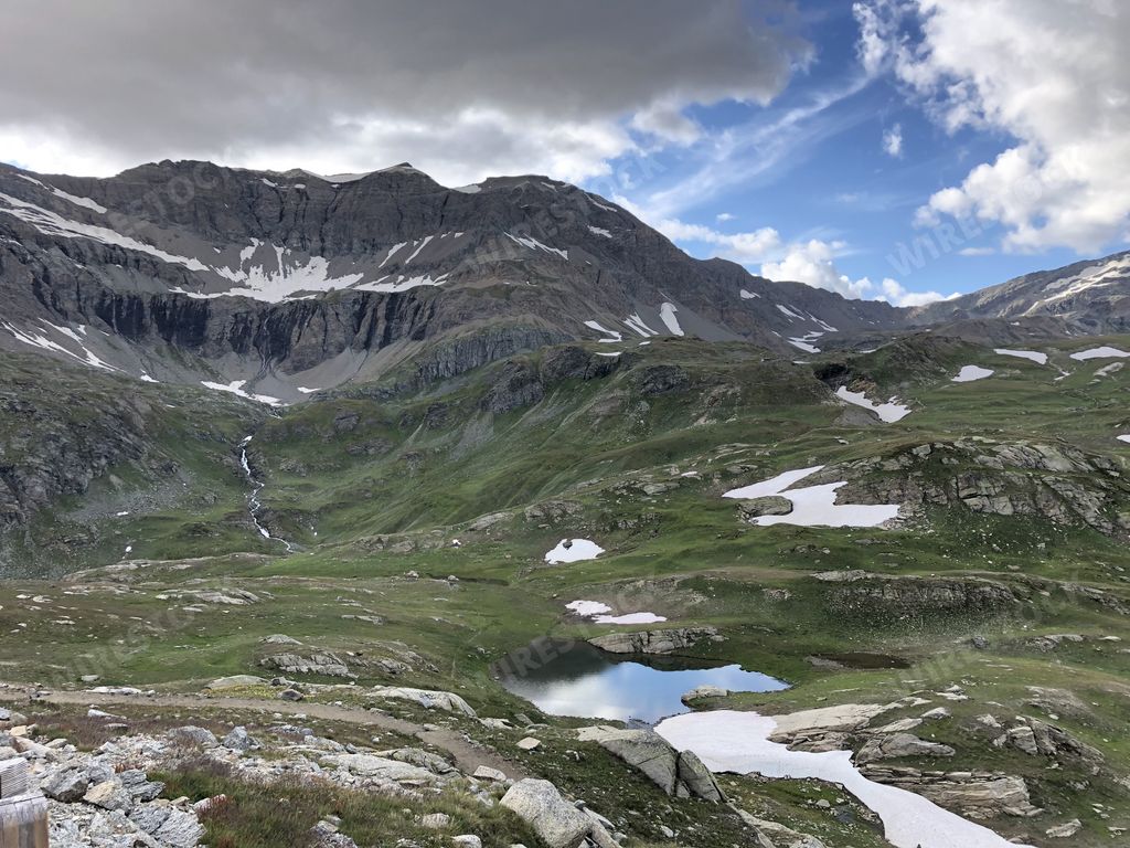 A panoramic shot of the Parco Nazionale Gran Paradiso Valnontey in Italy on a cloudy day background