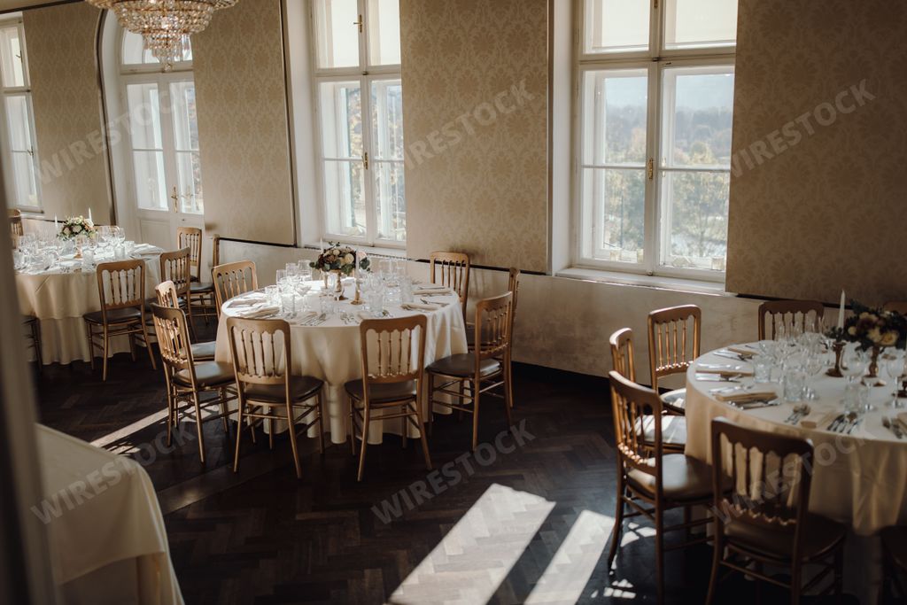 Wedding reception table adorned with floral arrangements, candles, and elegant seating