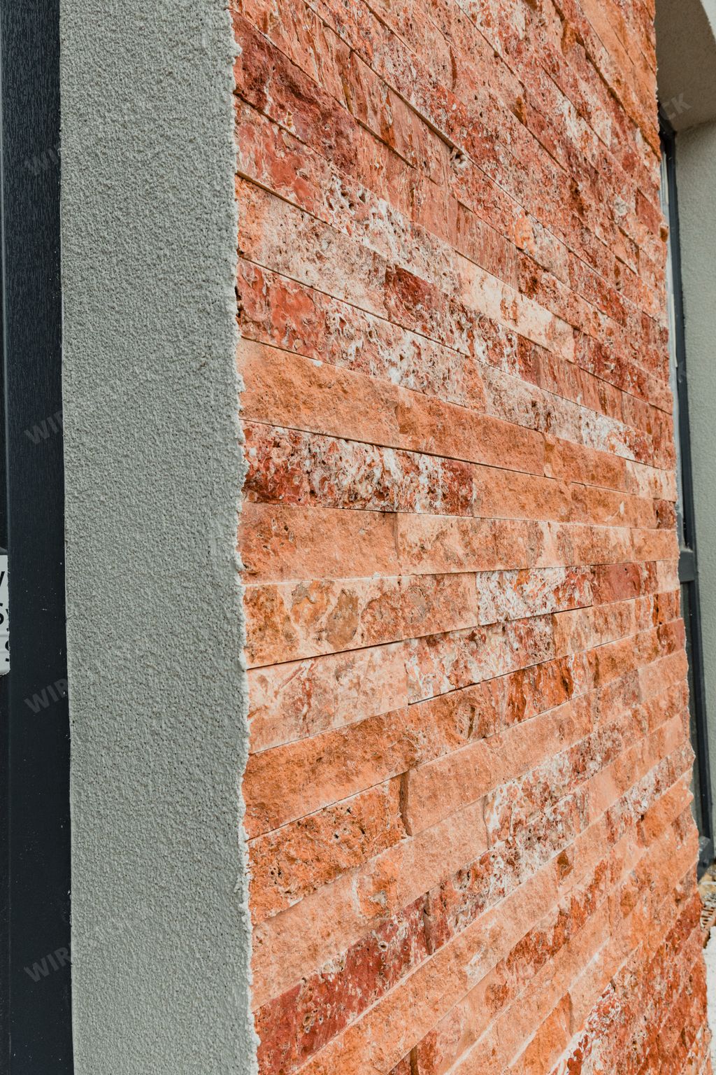 A closeup shot of a red brick wall near the window