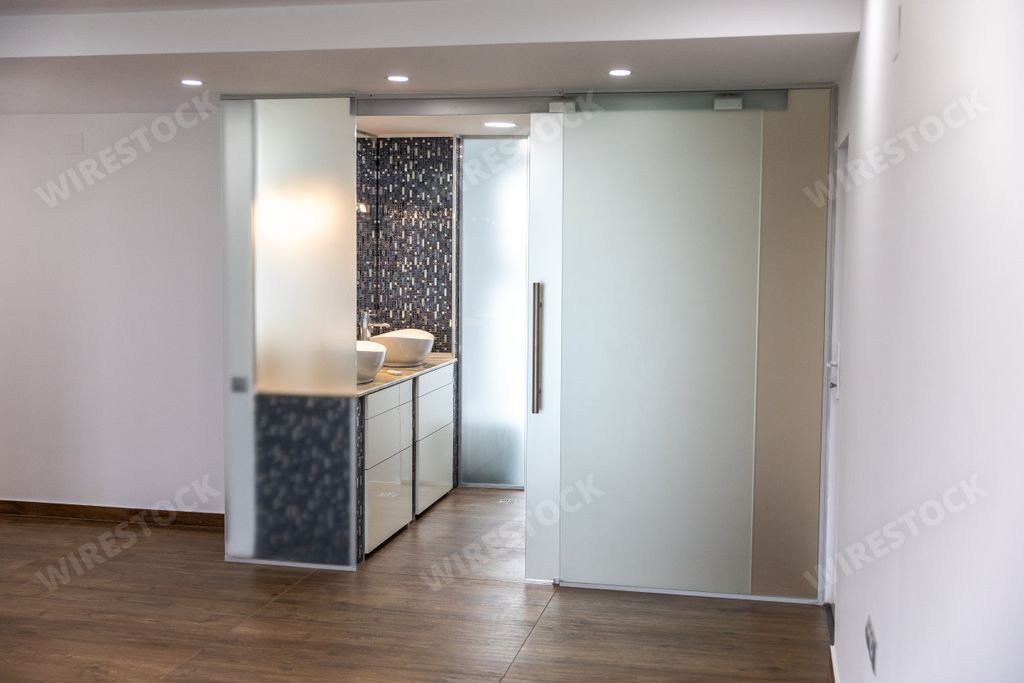 the interior of a clean bathroom with a transparent glass door and two white sinks