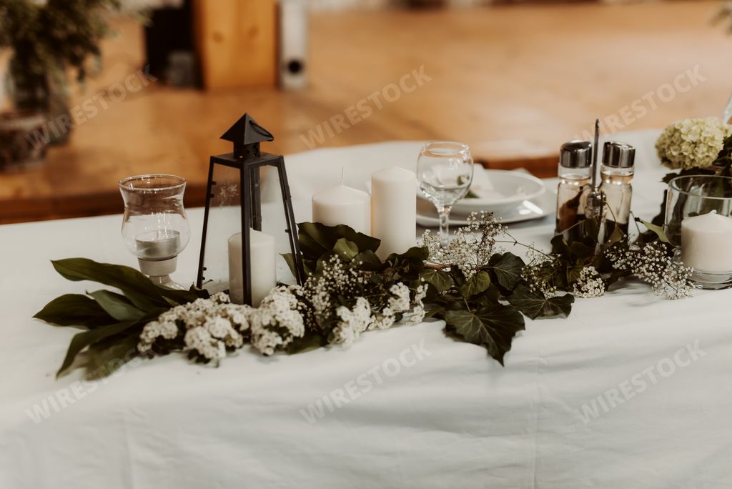 The candles decorated with flowers and leaves on the table