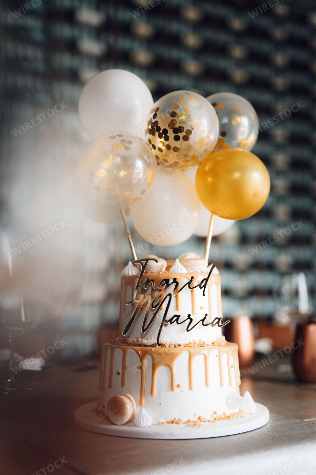 An appetizing yellow and white cake topped with festive balloons.