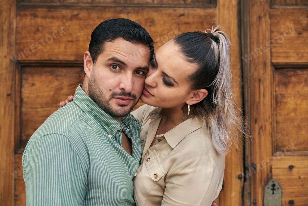 Young Latino male and female couple looking at each other in love between 25 and 35 years old