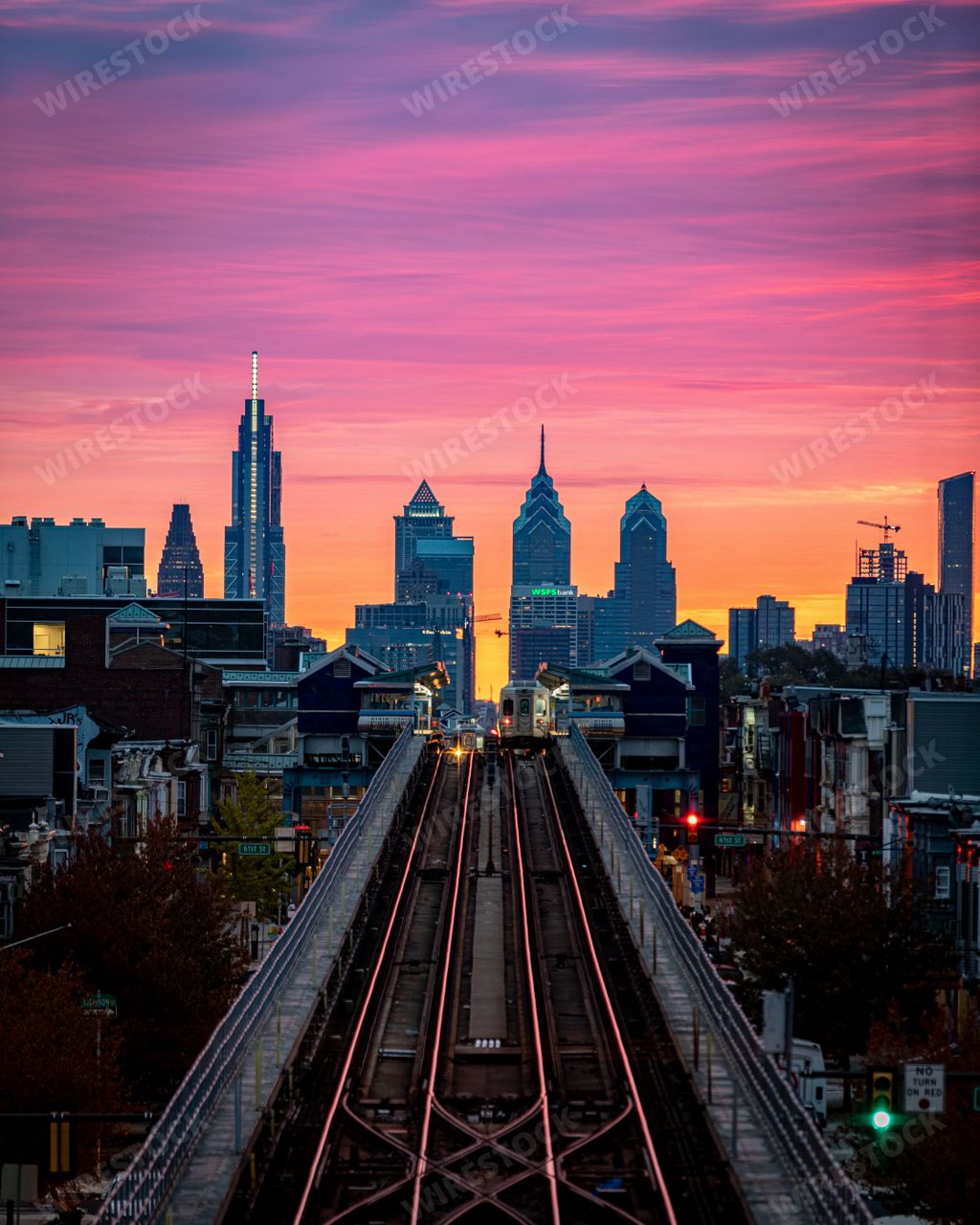 An aerial view of Benjamin Franklin Bridge and Philadelphia skyline on colorful sunset sky background