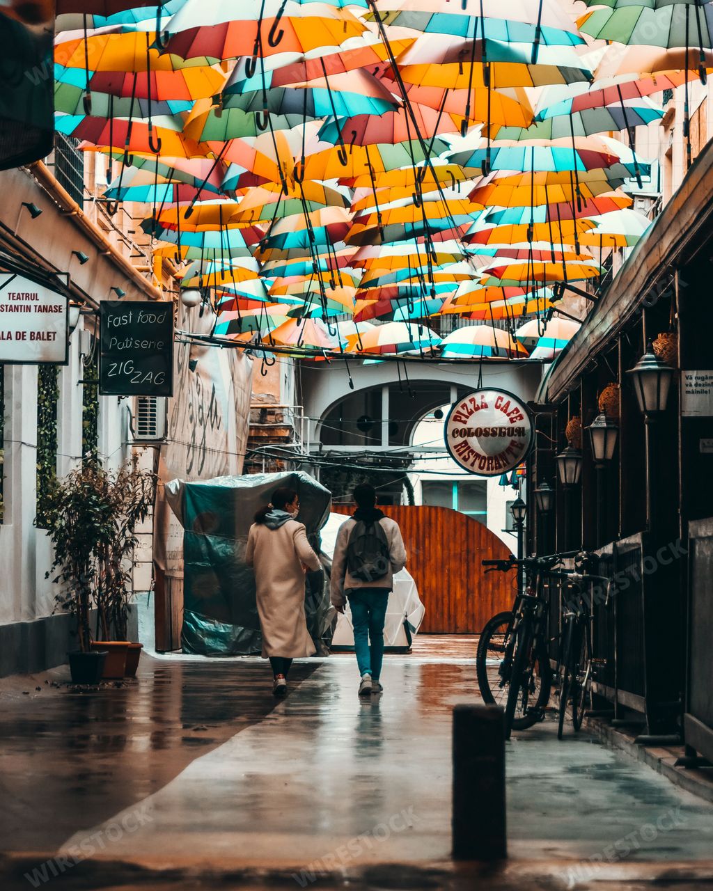 A vertical shot of colorful umbrellas over a pedestrian alley in Old Town Bucharest