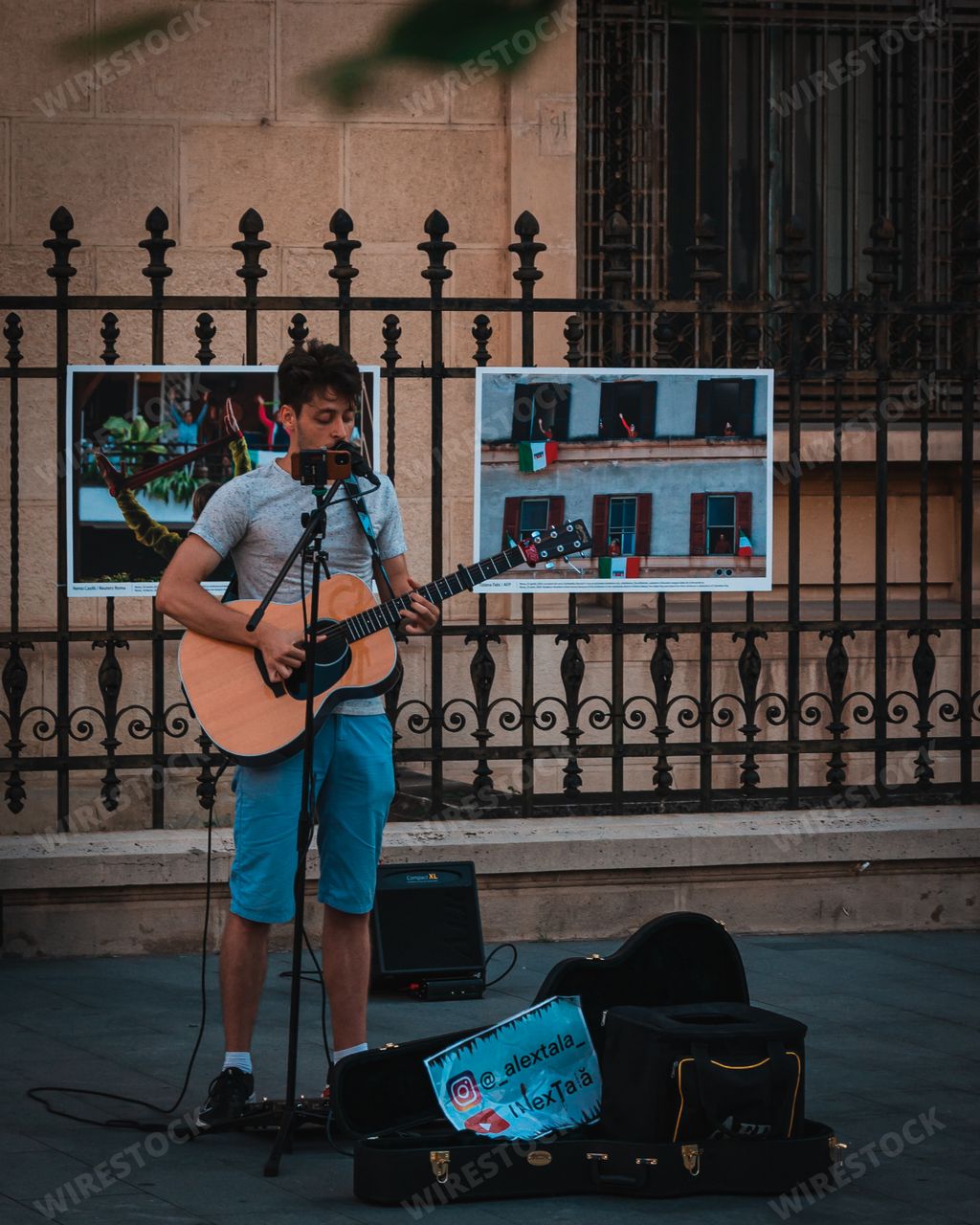 A vertical shot of a young male playing the guitar and singing on the streets of Bucharest, Romania