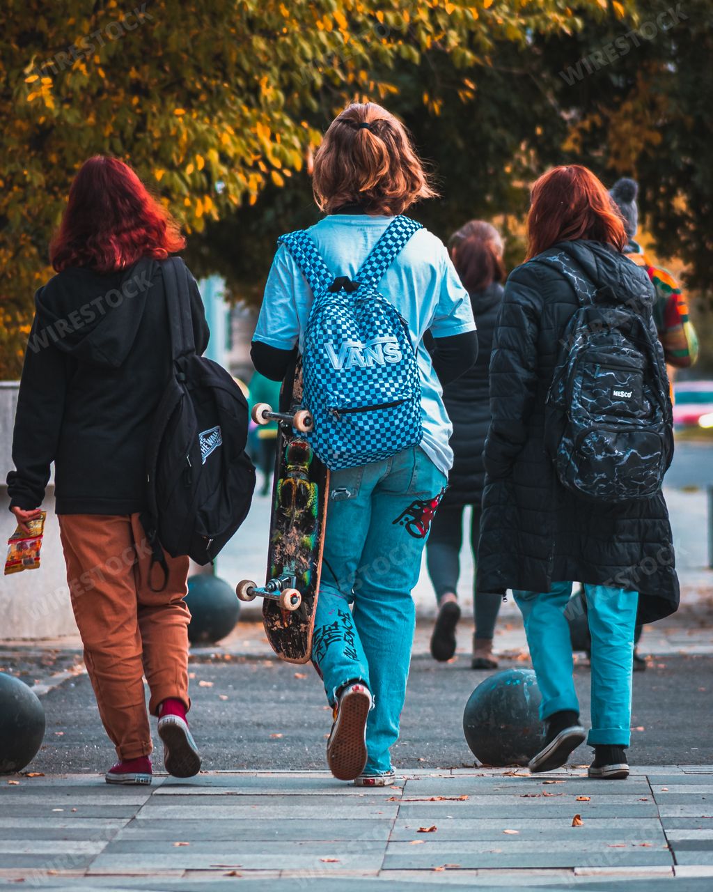 A vertical closeup of three girls walking in the streets in Bucharest, Romania