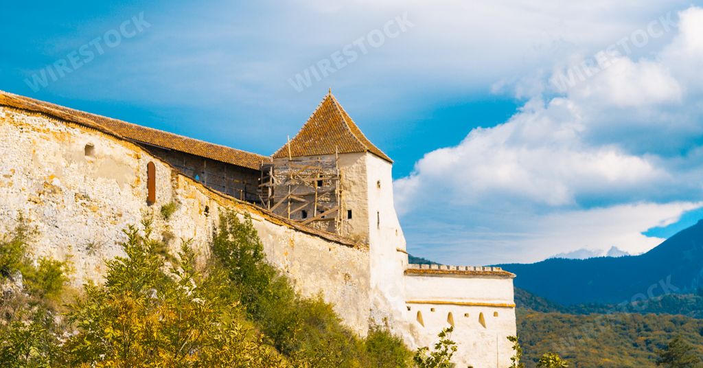 The famous historic Rasnov Citadel under a cloudy sky in Romania