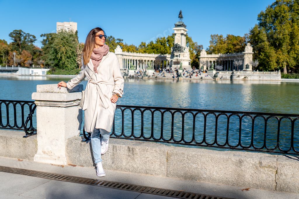 A shot of a young Caucasian girl on a fence in the Retiro park in Madrid, Spain