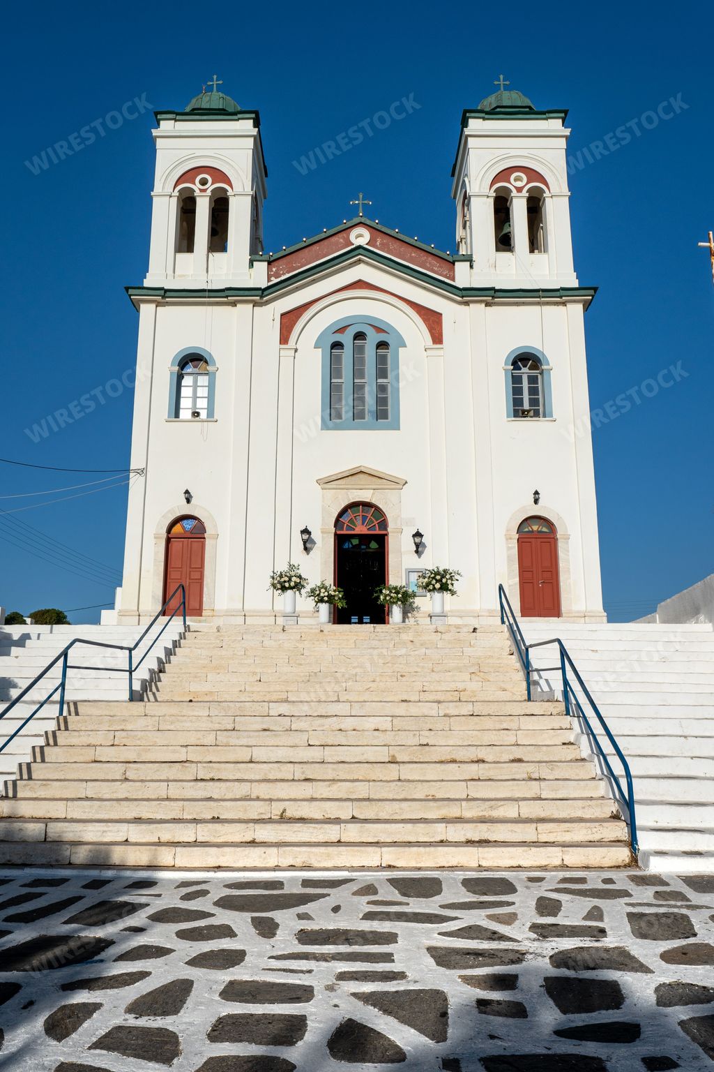 An impressive white building with a clock tower and multiple windows, standing tall against a blue sky