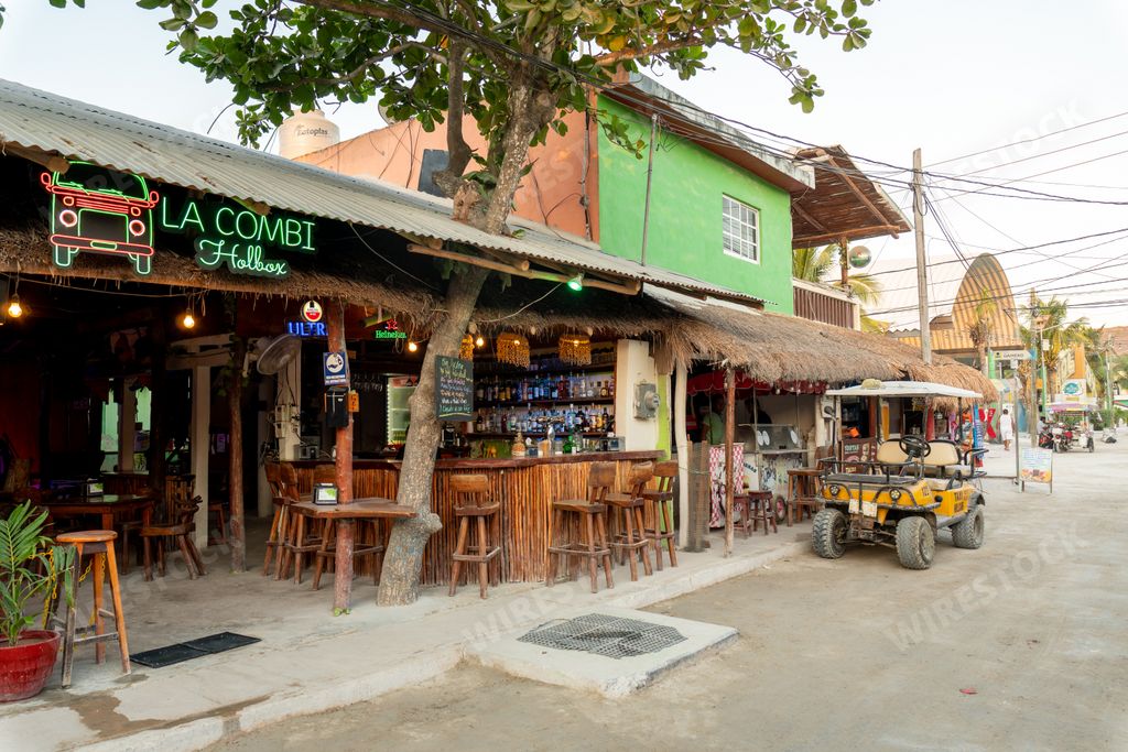 A shot of a bar restaurant and a golf cart taxi on a sandy street, Holbox, Mexico