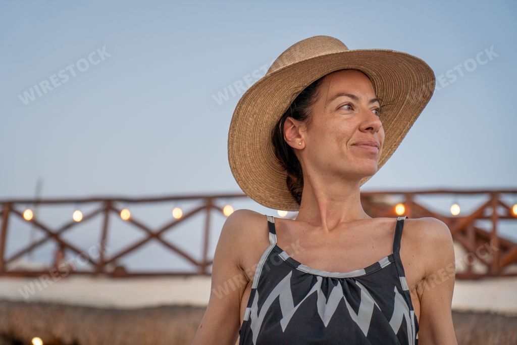 A beautiful Spanish woman on a wooden platform on a beach in Holbox, Mexico