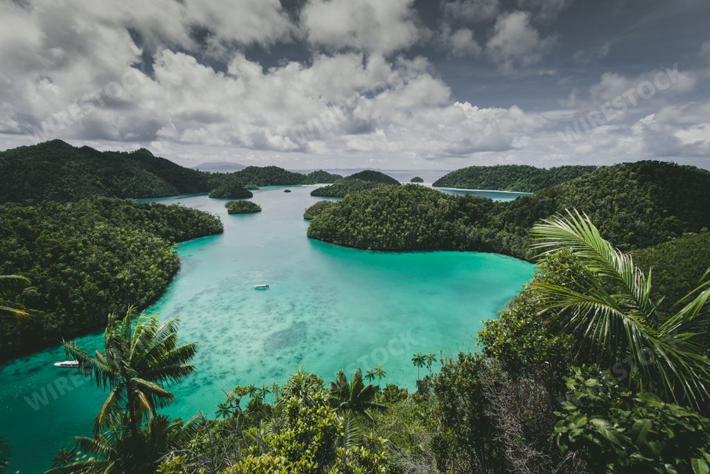 A landscape of the Wajag Island surrounded by the sea under a cloudy sky in Indonesia