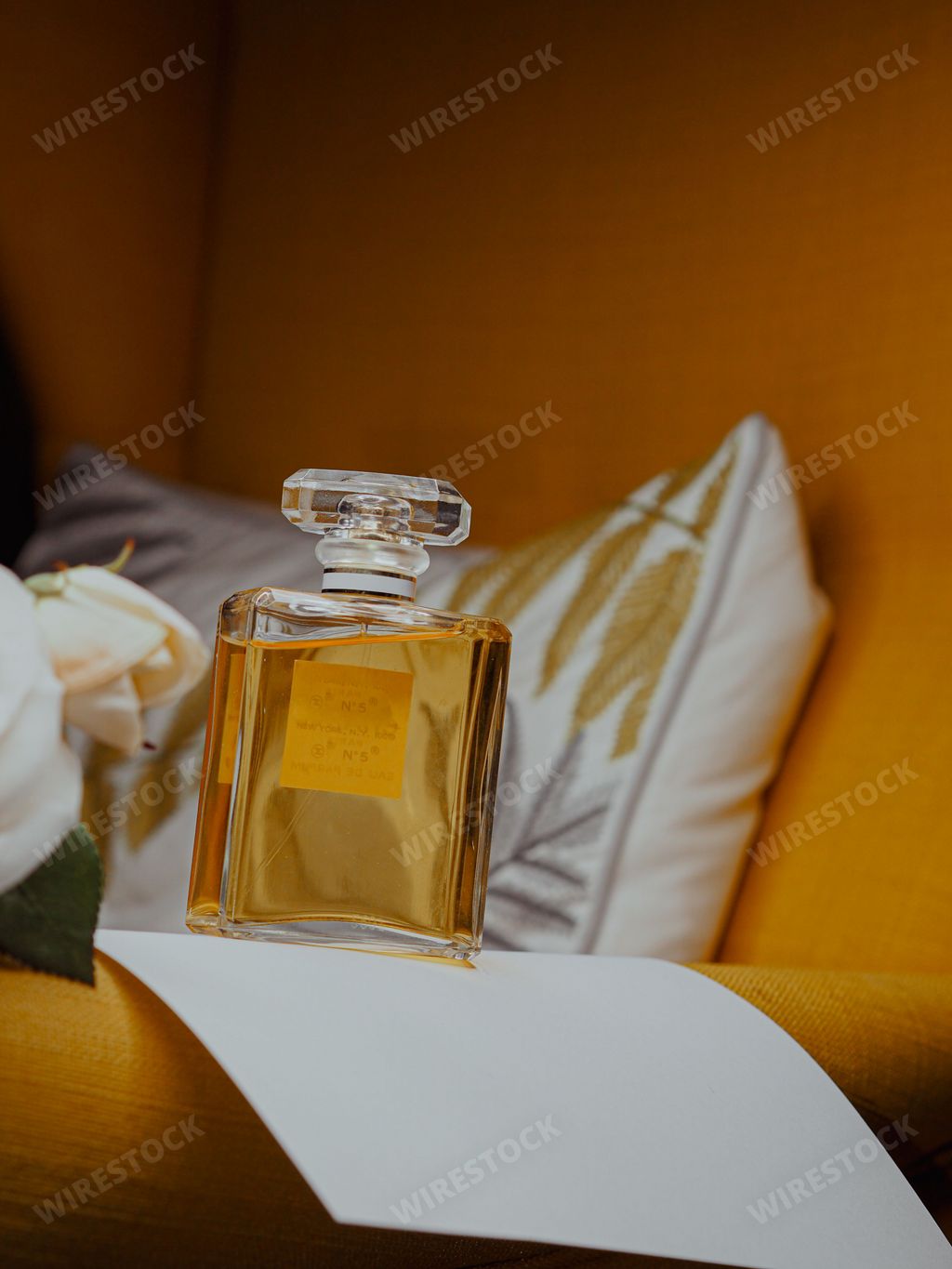 A vertical shot of an aesthetic clear perfume bottle with gold substance
