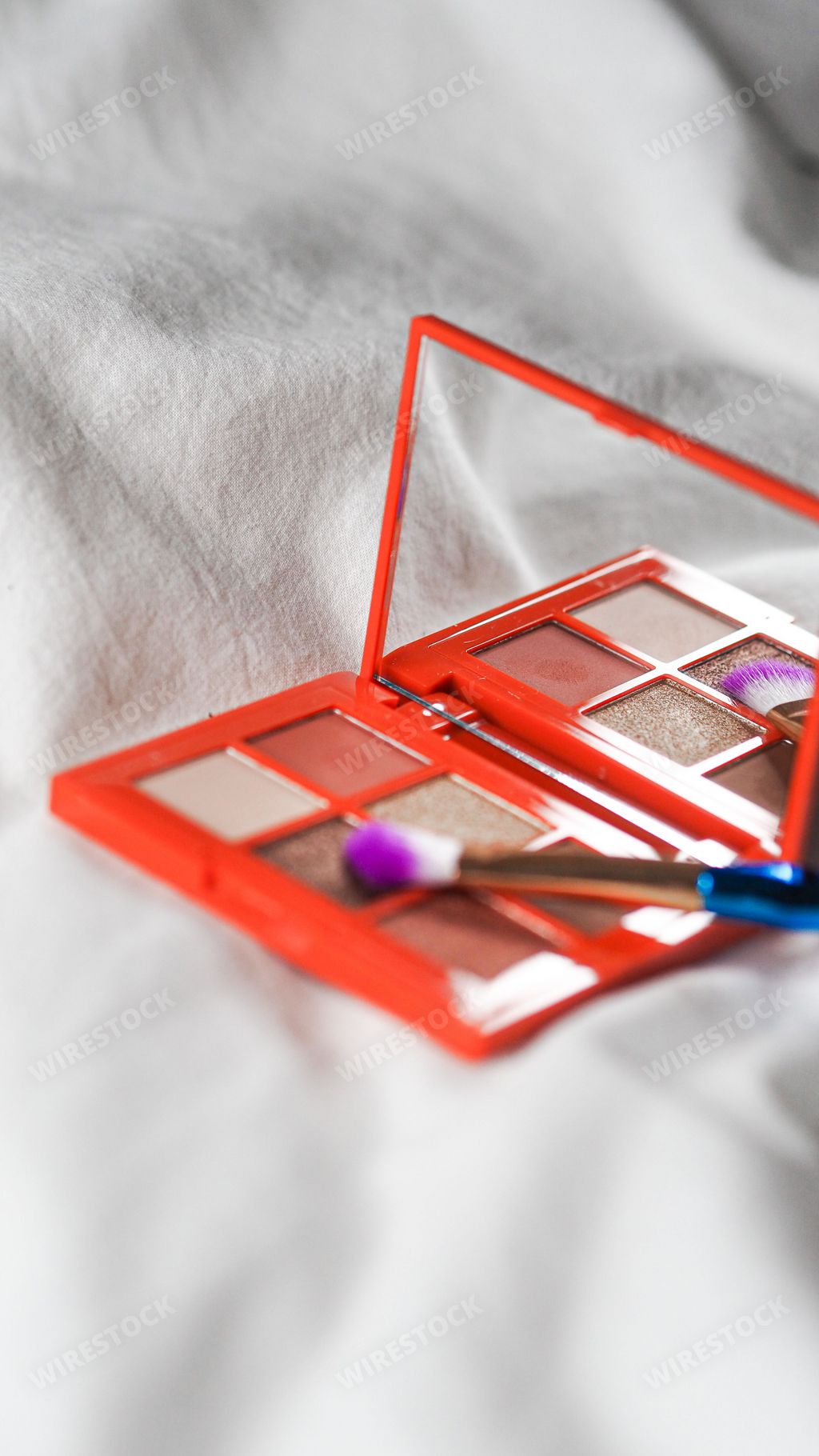 A vertical shot of a palette and a brush on the white background