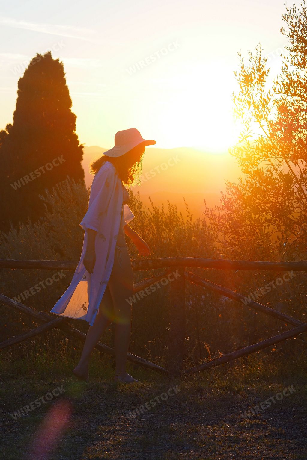 A scenic view of a silhouette of a woman of Tuscany at golden sunset