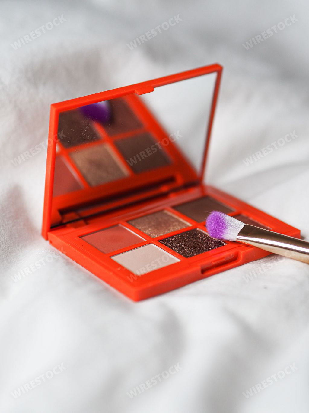 A vertical shot of a palette and a brush on the white background