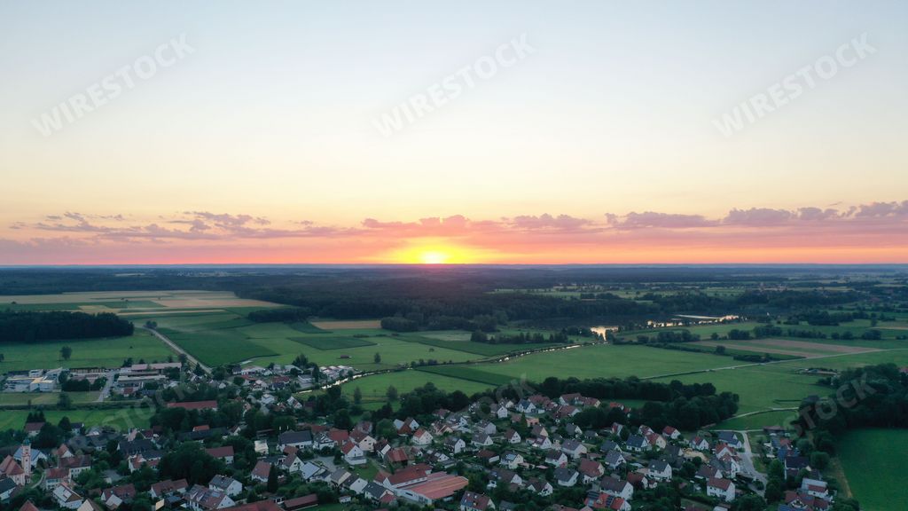 An aerial view of greenery field with buildings in Germany during sunset