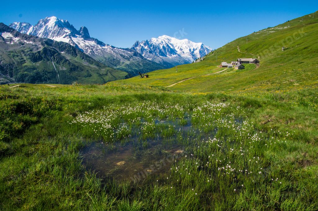 A landscape of wet grass and houses in charamillon gondola snowy alps in Haute Savoie, France