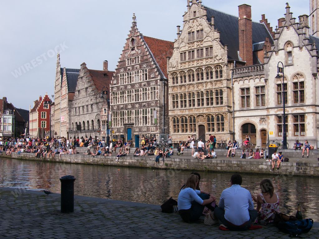 A cityscape of the beautiful Gand port city on the banks of the Leie river full of tourists in Belgium