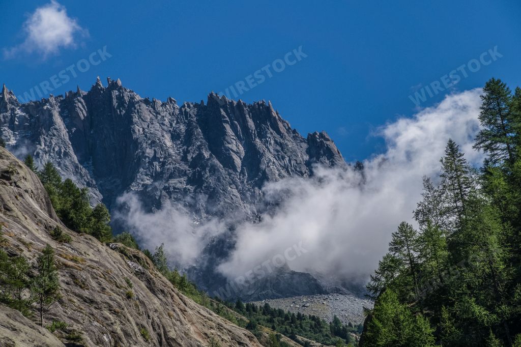 A beautiful shot of a rock in the background of a mountain.