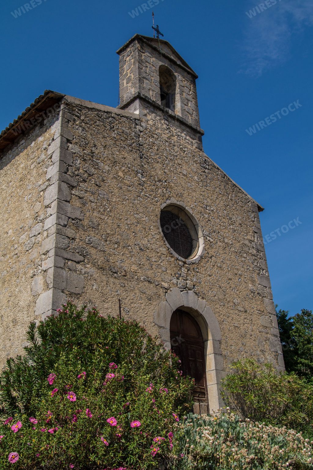 A low angle view of an exterior stony building of Santuari de Queralt Berga Spain against a blue sky
