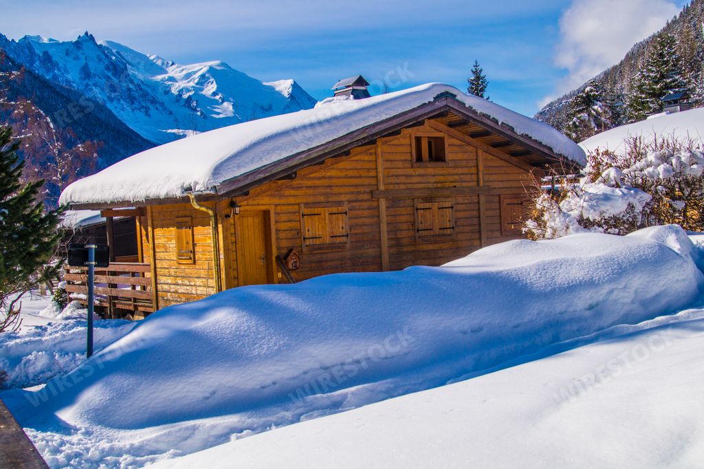 A beautiful view of the wooden houses surrounded by snowy mountains in France
