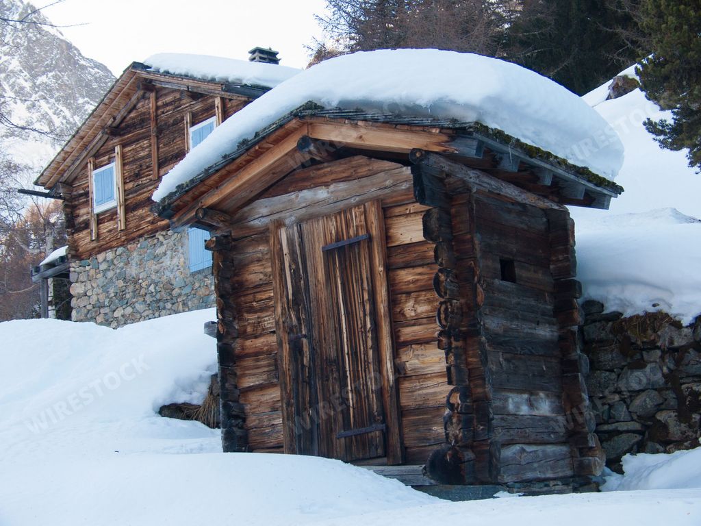 A snow-covered wooden houses in a forest during winter
