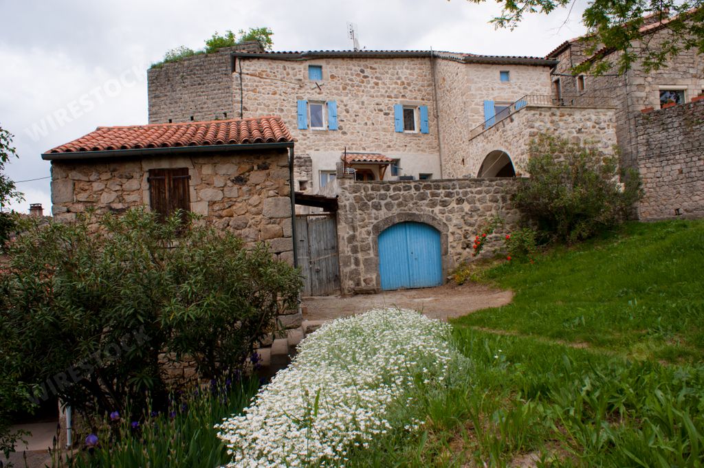 A rural house with green grass and plants in Montreal, Ardeche, France