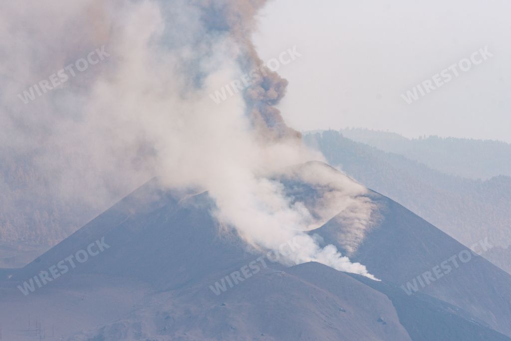 Thick steam coming out of the top of a volcano mountain