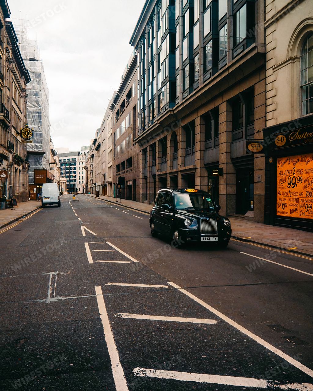 A vertical shot of a taxi driving on the streets of London, England