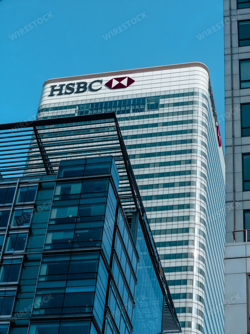 A vertical low angle shot of the HSBC bank building in Canary Wharf in London