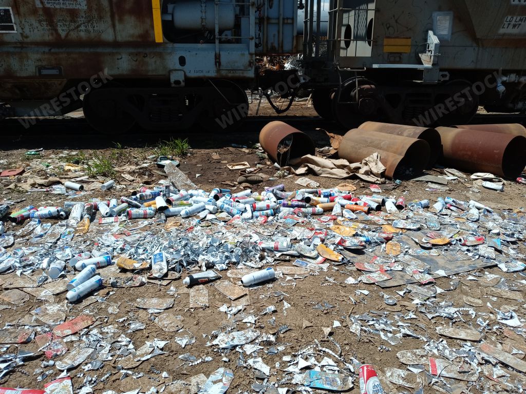 An old abandoned train station site with littered trash and metal tubes