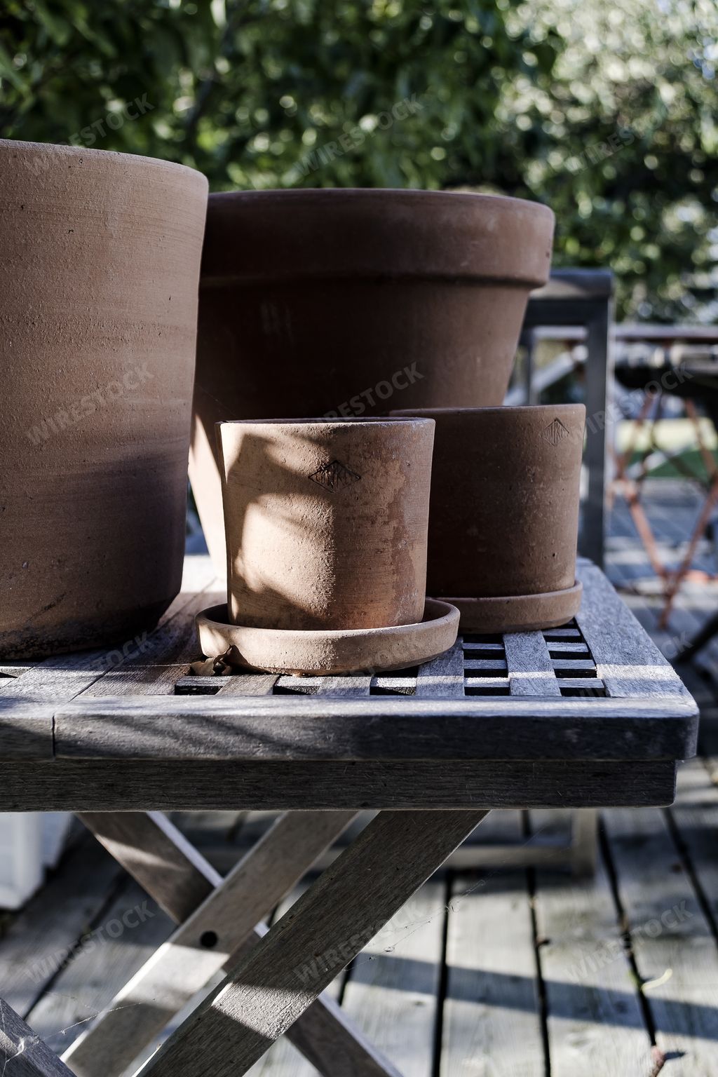 A vertical shot of clay pots of different sizes on a wooden coffee table
