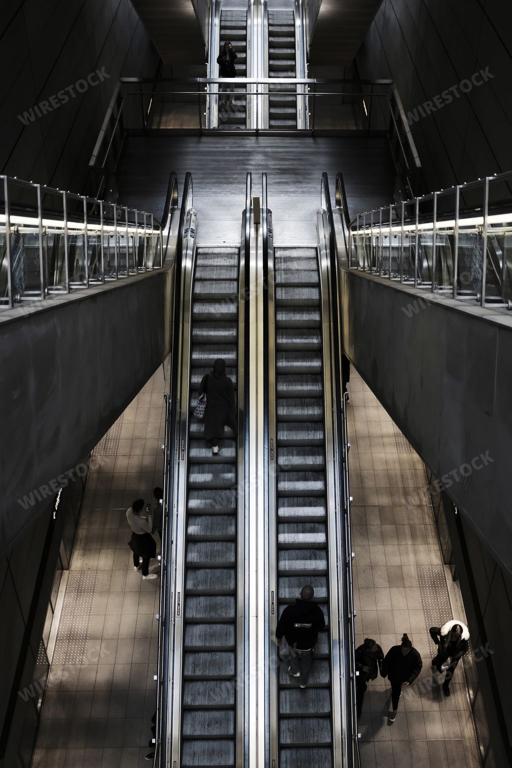 Overhead shot of an escalator at a train station with people on it