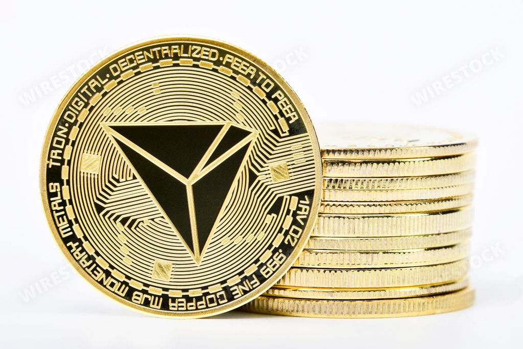 A closeup shot of TRON cryptocurrency coins on a white background