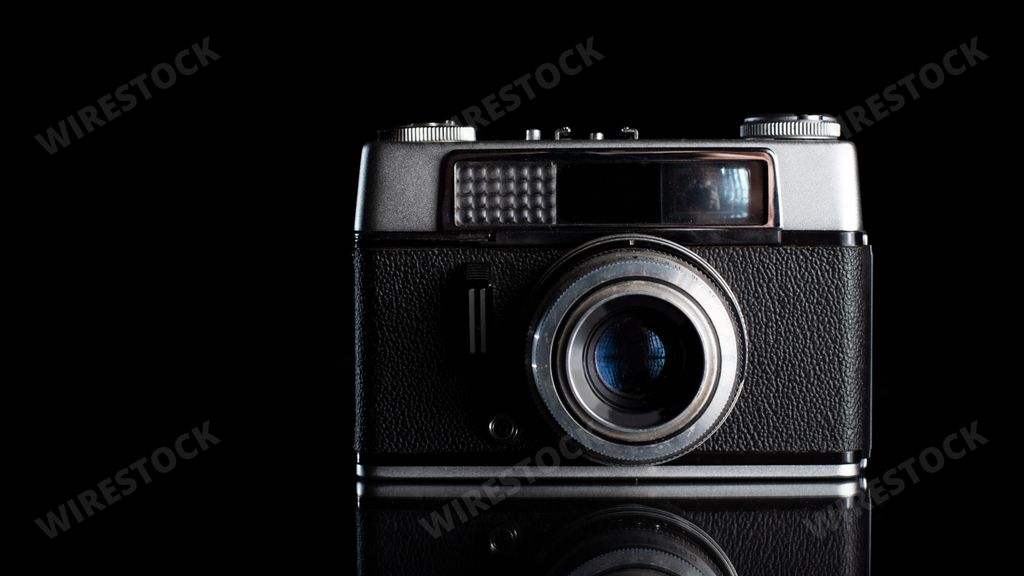 A closeup of a retro camera isolated on a black background - vintage
