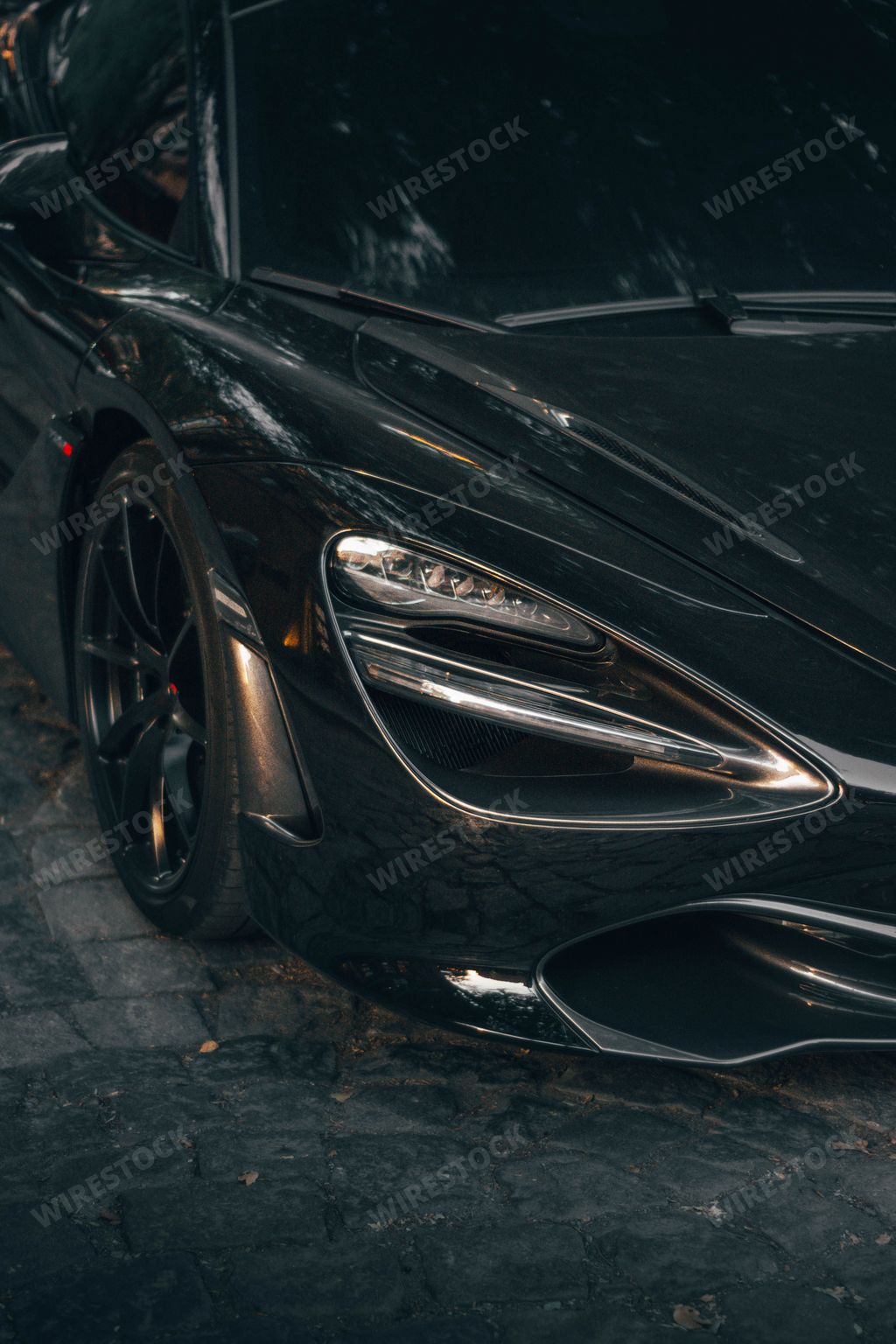A vertical shot of the front and the headlight of black McLaren luxury sports car