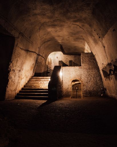View of a an underground hall with arched ceiling and stone walls and ...
