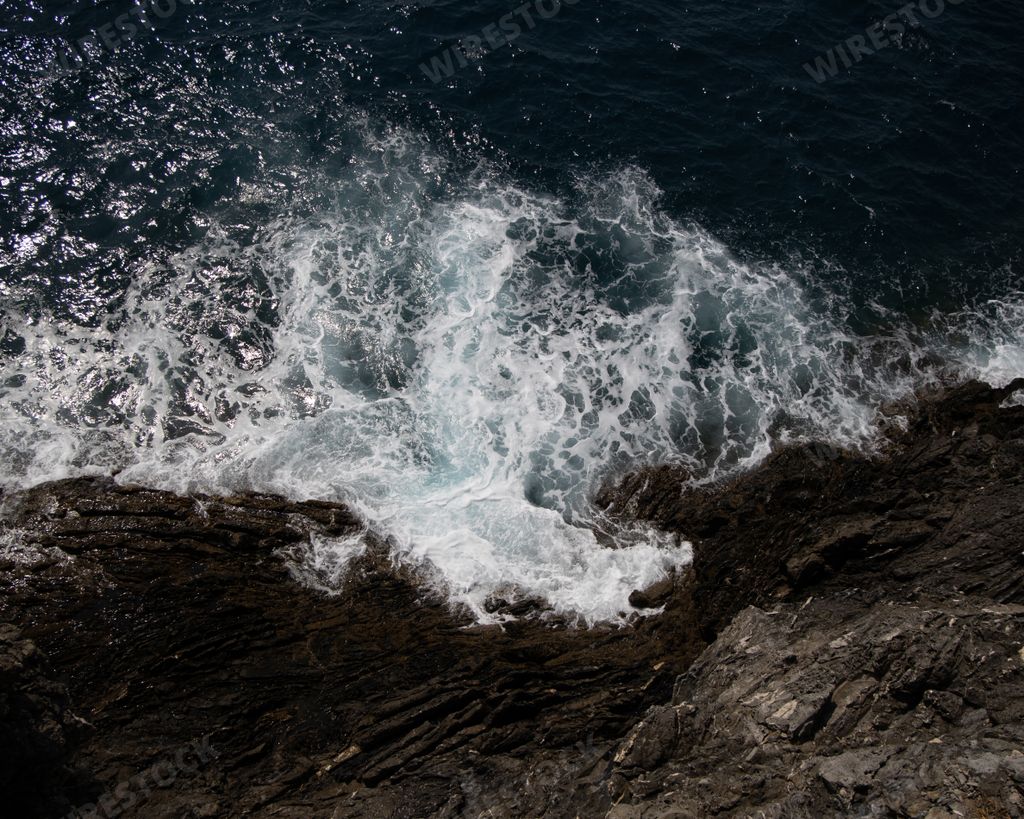 The sea wave crashes on a rocky shore
