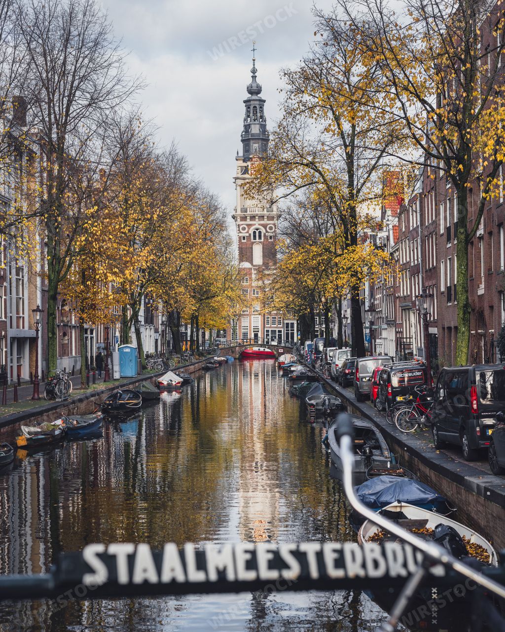 Amsterdam, Netherlands - November 27 2022: A famous view of the Zuiderkerk Tower in Amsterdam. Taken from the Staalmeesterbrug bridge over a canal in