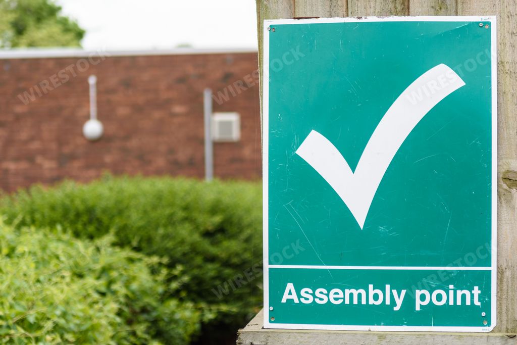 A fire assembly point sign indicates the rendezvous point in case of emergency.