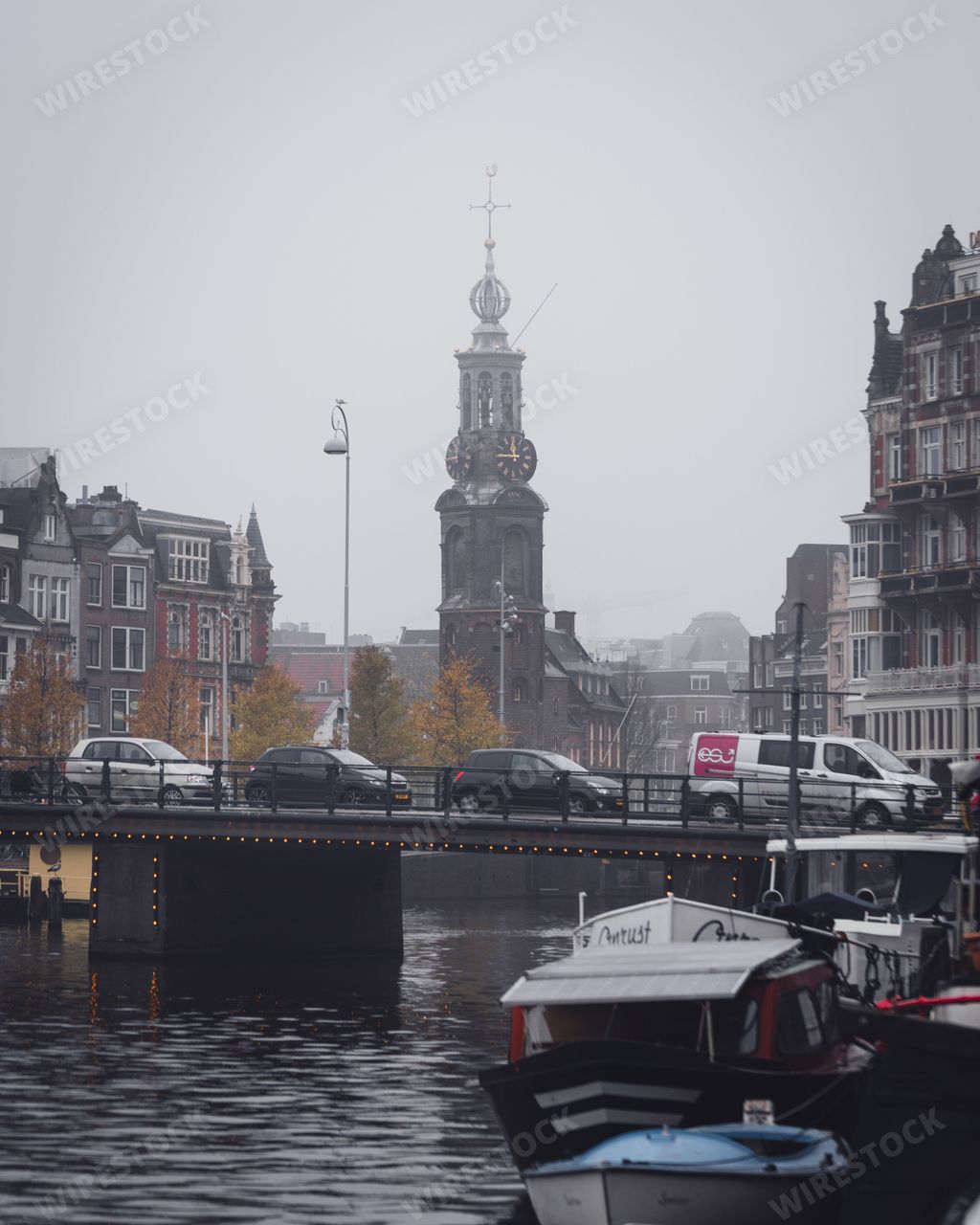 Amsterdam, Netherlands - November 27 2022: Munttoren tower from the river Amstel on a grey, foggy autumn day.