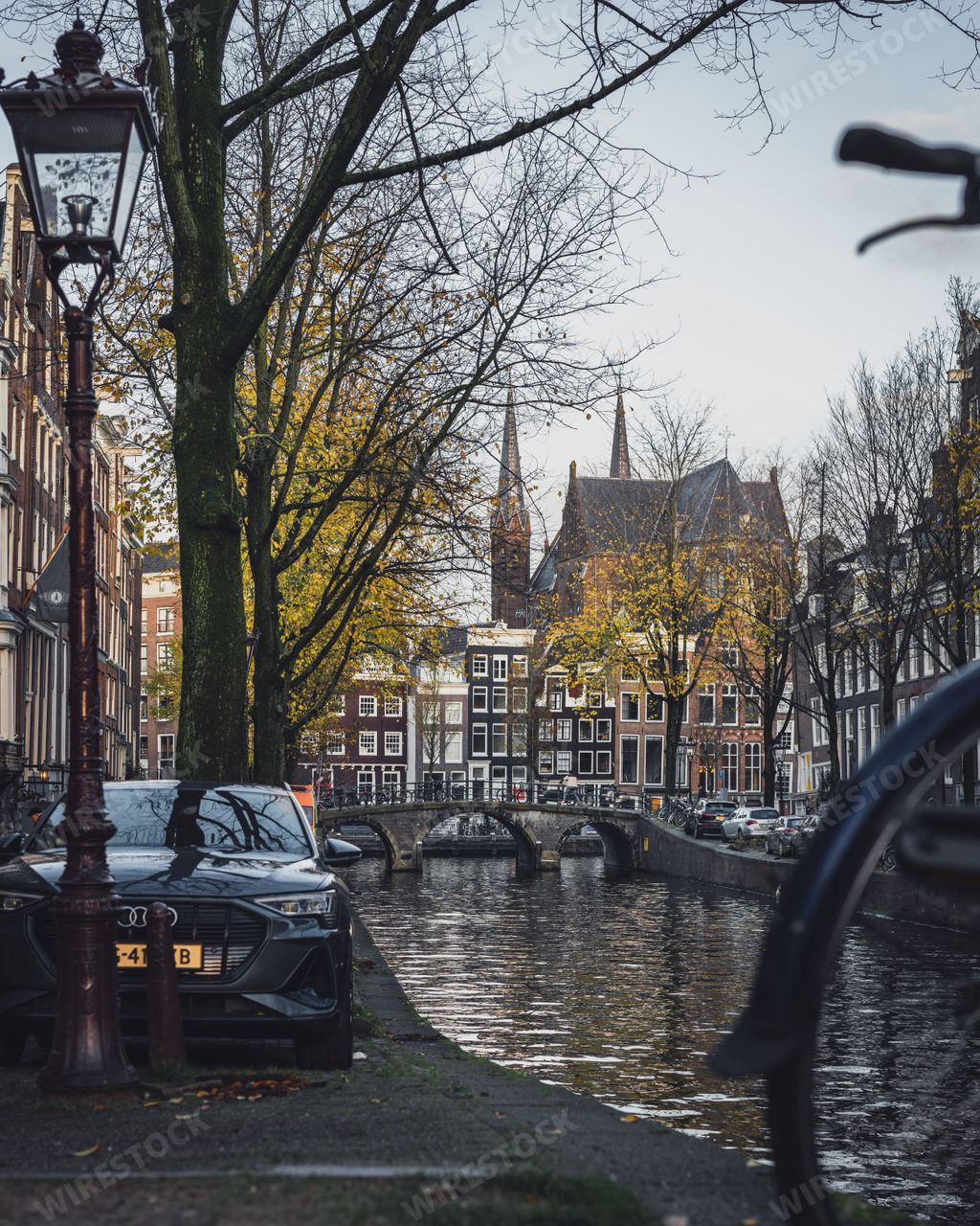 The bicycles parked up next to the canal in autumn in Amsterdam, Netherlands