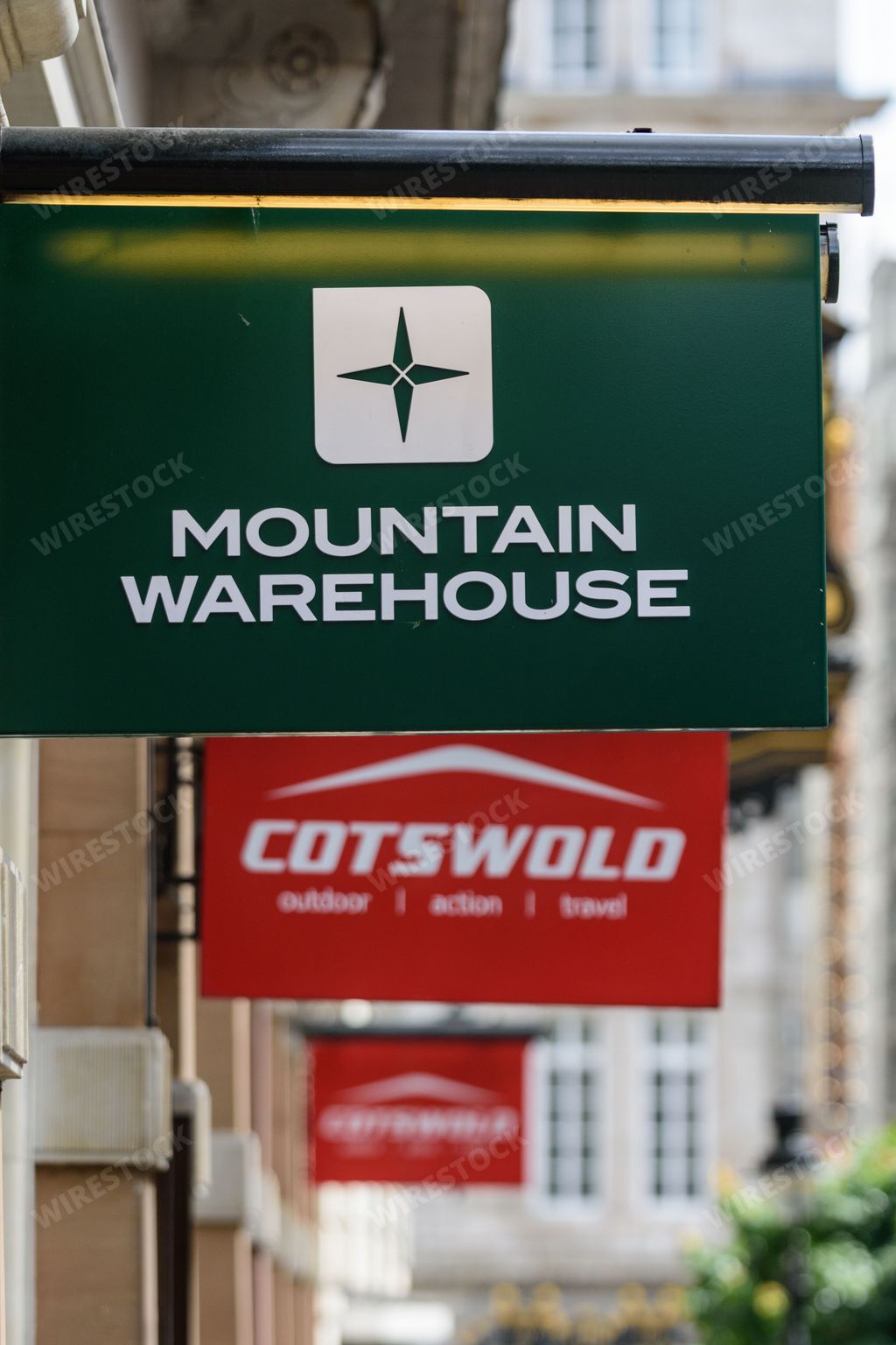 Signs outside outdoor shops Mountain Warehouse and Cotswold outdoor advertise their brands and stores to shoppers on a high street in London, UK