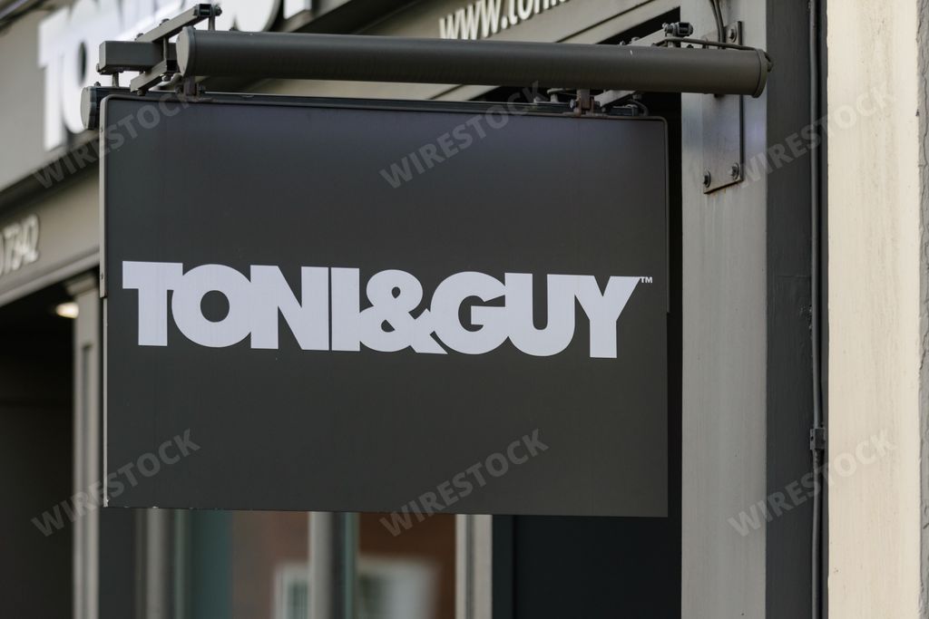 A sign outside a Toni and Guy hair salon in central London advertises their hairdressing and beauty services to men and women