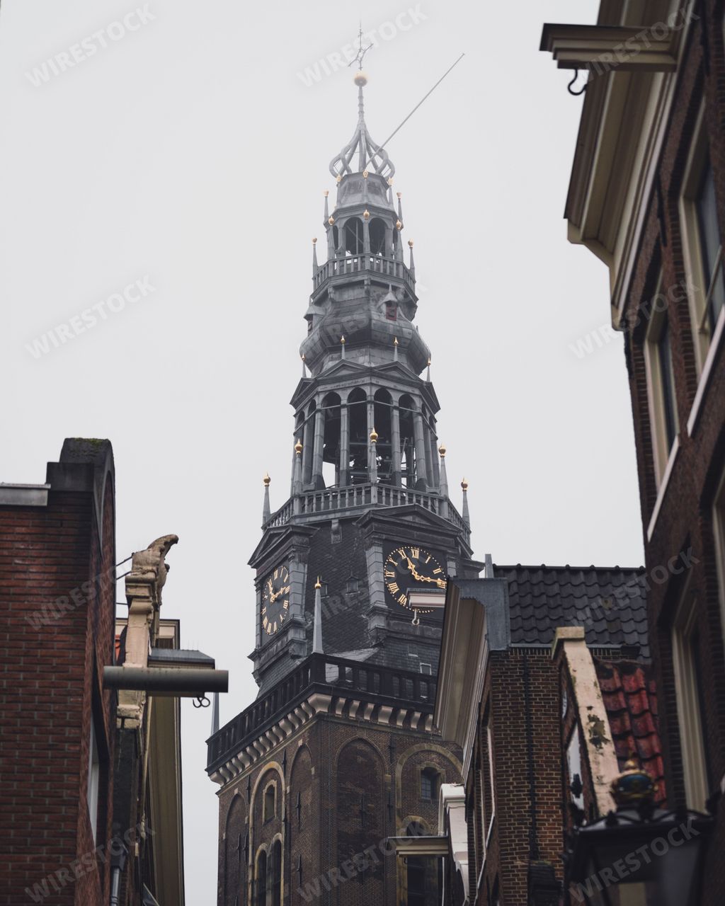 Amsterdam, Netherlands - November 27 2022: A close up of the spire to the Oude Kerk church in the red light district of Amsterdam on a foggy morning.