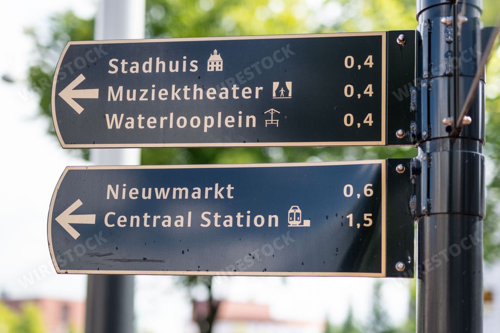 A street sign in Amsterdam, Netherlands directs people towards various city centre attractions, such as Nieuwmarkt and Centraal Station.