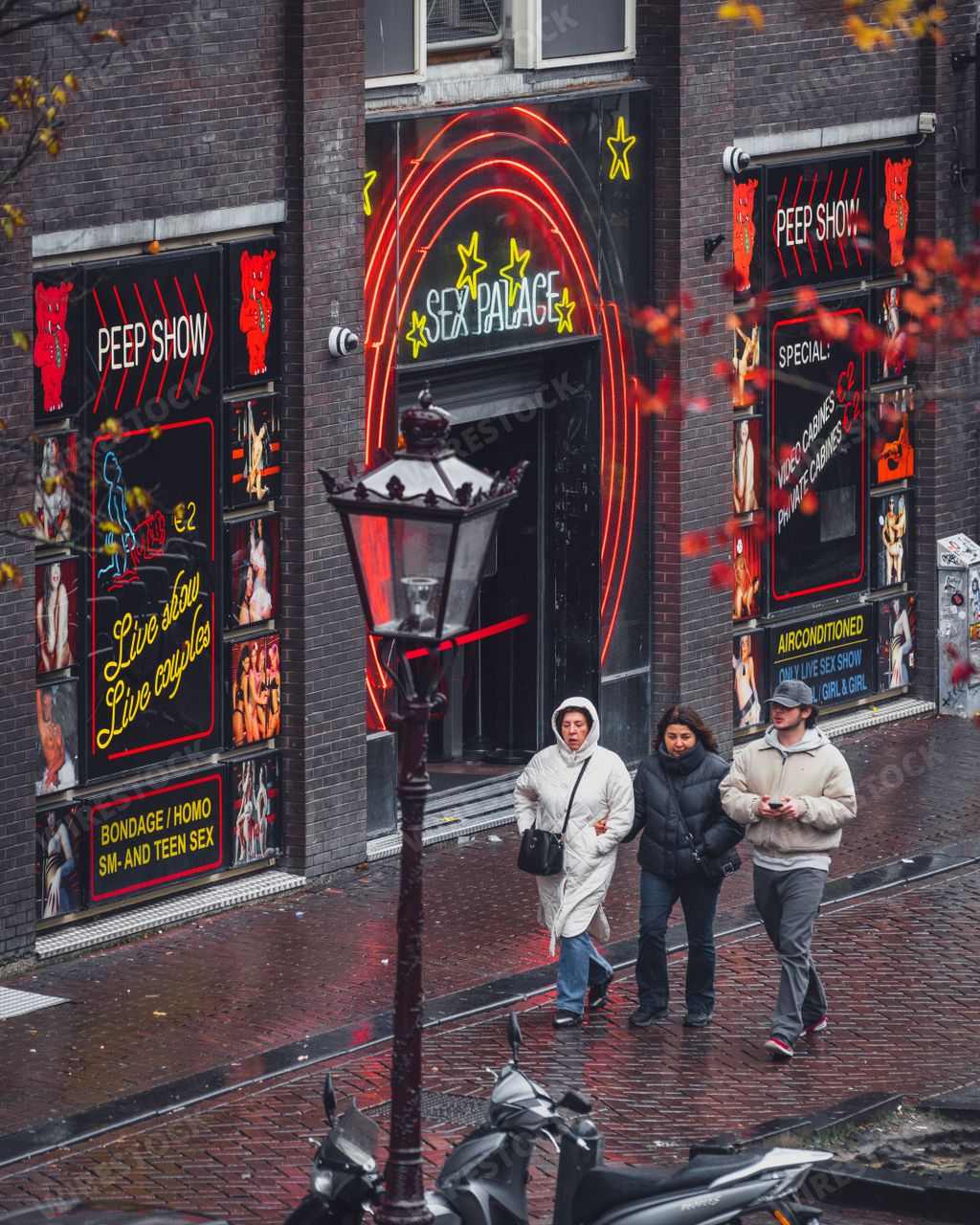 People pass by the Sex Palace peep show and erotic club in the De Wallen red light district in Amsterdam.