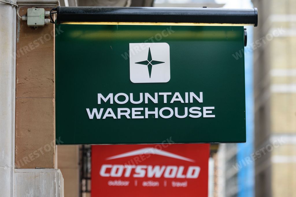Signs outside outdoor shops Mountain Warehouse and Cotswold outdoor advertise their brands and stores to shoppers on a high street in London, UK